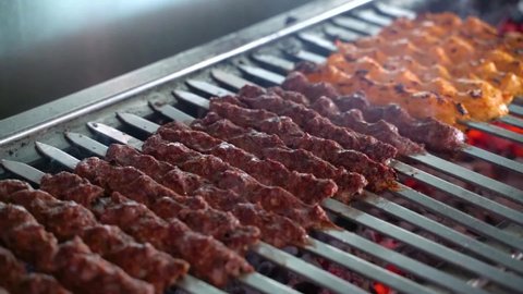 tikka, shish & kofta kebabs on charcoal barbeque with smoke