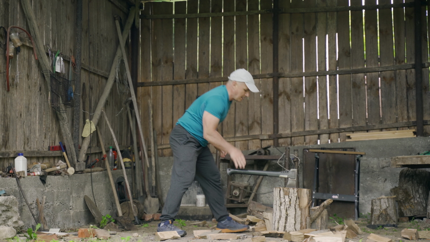 Man splitting wood for barbecue or fireplace in a shed