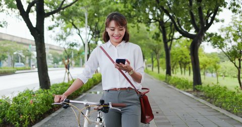 Asian businesswoman commute with her bicycle in the streets happily