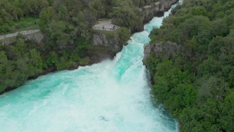 SLOWMO - Aerial drone shot of spectacular waterfall Hukas Falls and tourists at viewpoint, New Zealand