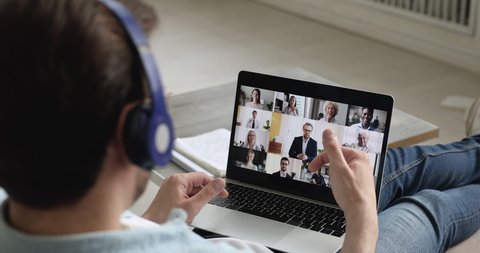 Pc screen where diverse people take part at group video conference, view over male shoulder participant of video call. Telework easy and convenient, modern tech, work from home due quarantine concept