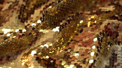 Gold sequin fabric. Holiday abstract glitter background with blinking lights. Fashion luxury fabric glitter, spangles, paillettes.