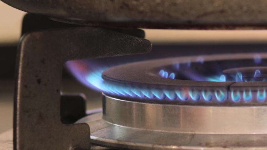Turning the flames on to heat the stainless steel pan for cooking - Close up Royalty-Free Stock Footage #1058588611