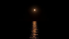 reflection of the moon in the sea. Full moon at night reflected in the water. moonlight bright sea reflection. A clear large distinct moon shines over the ocean in an eerie night scene - Powered by Shutterstock - Get 15% off with code: PIKWIZARD15
