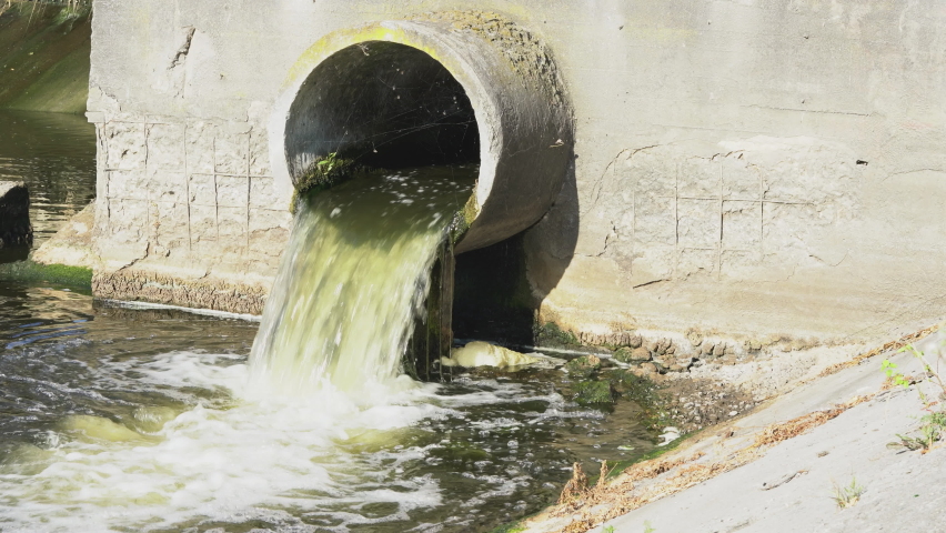 Dirty water flows from the pipe into the river, environmental pollution. Sewerage, treatment facilities | Shutterstock HD Video #1058597671