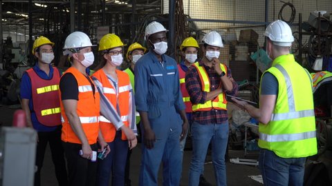group of factory workers wear protective face mask meeting in industrial factory protect for pollution and coronavirus pandemic or covid 19 outbreak 