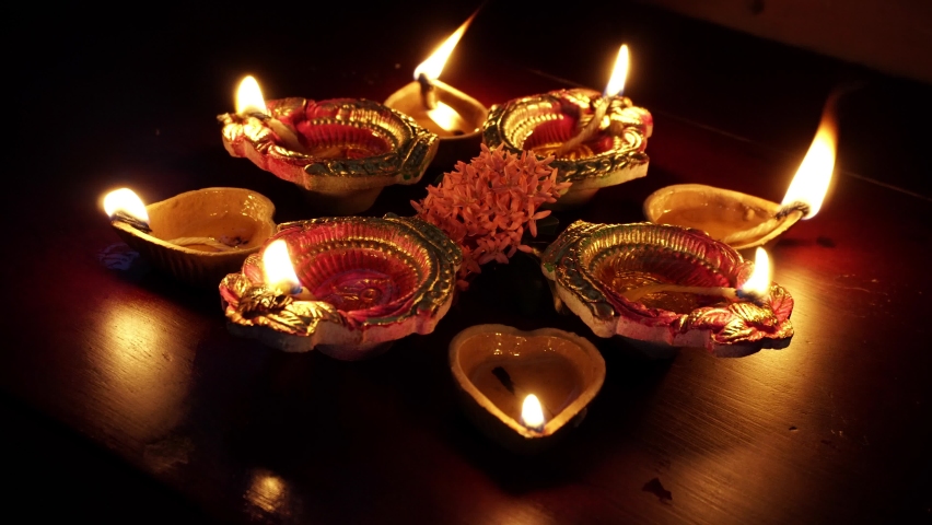 Colorful Diwali oil lamps, Deepavali oil lamps lighted in beautiful formation with flowers in middle.Decorative Colorful diya lamps lit during diwali celebration. Royalty-Free Stock Footage #1058607727