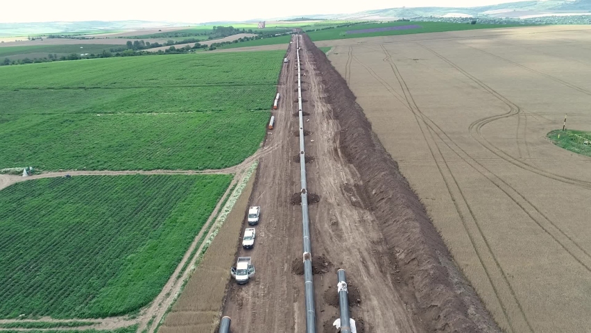 Aerial view of gas and oil pipeline construction. Pipes welded together. Big pipeline is under construction. Royalty-Free Stock Footage #1058608609