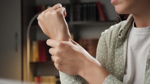 Pain in wrist. Female hand touches wrist and tries to stretch joint. Tendinitis, synovitis, osteoarthritis, sprain, rheumatoid arthritis concept. Close-up