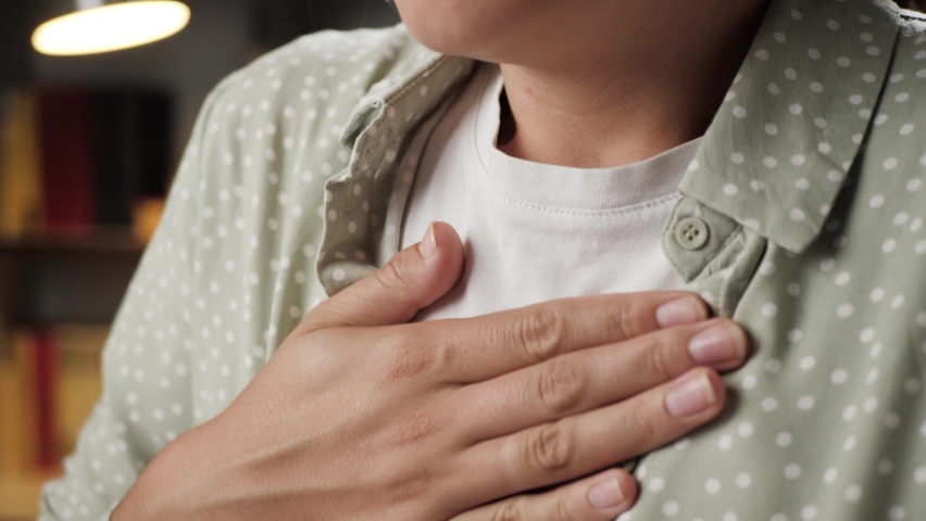 Breathing problems, chest pain. Woman has difficulty breathing, female hand touches chest. Heart attack, thoracic osteochondrosis, panic attack concept. Close-up | Shutterstock HD Video #1058608843