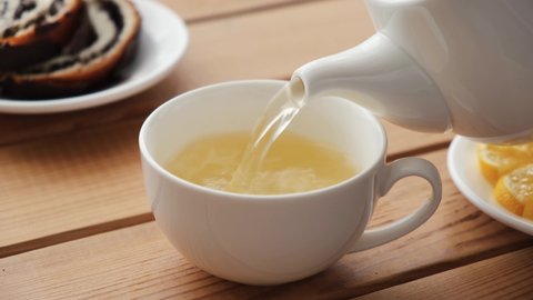 Pouring green tea Oolong in a cup. Healthy chinese tea rich in antioxidants