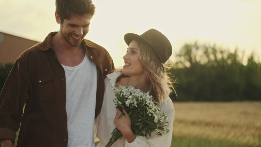 Smiling couple man and woman are walking together in the countryside