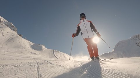one Man downhill skier slowly down the ideal ski slope. Skiing on the track against the backdrop of picturesque snow-capped mountains. Winter outdoor activities. Slow motion, 2K RAW footage, 2704x1520