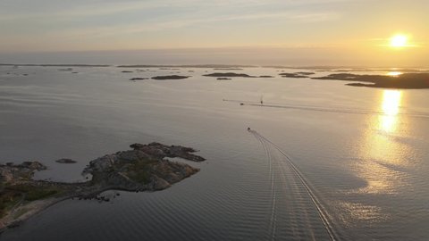 Boats heading towards a beautiful sunset on the west coast in the summer. 4K stabilized aerial footage. Hovås, Sweden.
