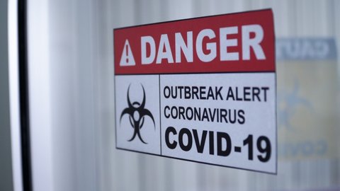 Coronavirus outbreak alert sign with biohazard symbol on the glass door.