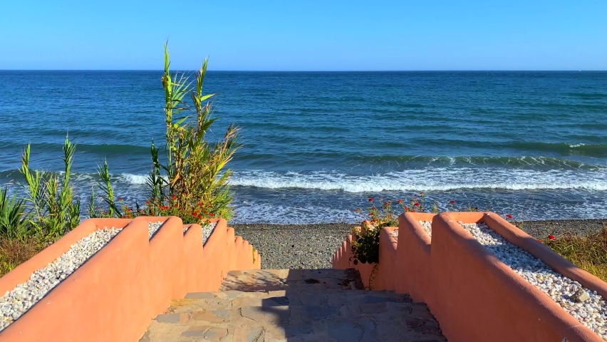 Beautiful stairs to the ocean, steps leading down to the sea in Marbella Estepona, Spain, 4K static shot