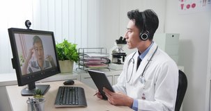 Telemedicine concept - asian young doctor wear headset who is listening to elder patient and then talking about his symptom online