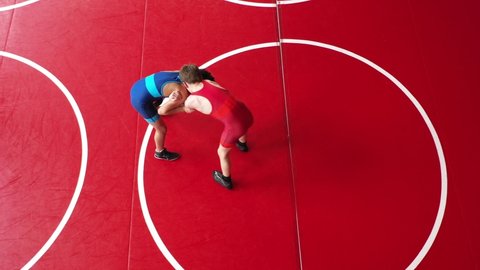 Unique overhead view of youth wrestlers practicing a shot to a bear hug