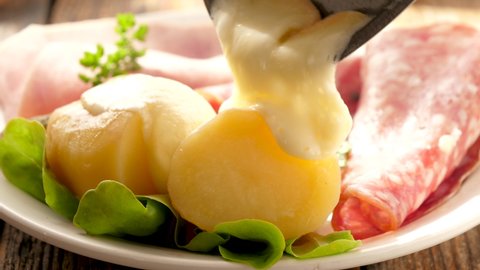 raclette cheese melting on potato and salami