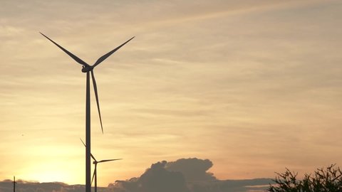 Wind turbine farm on beautiful golden sky evening landscape. Renewable energy production for green ecological world. 庫存影片