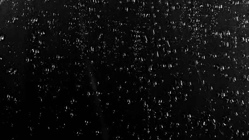 Water Drops following down on black background. Drops of Rain trickling down isolated. Perfect for digital composing. Best 4K High Quality footage Droplets of Water on Black Glass running down.  Royalty-Free Stock Footage #1058658010