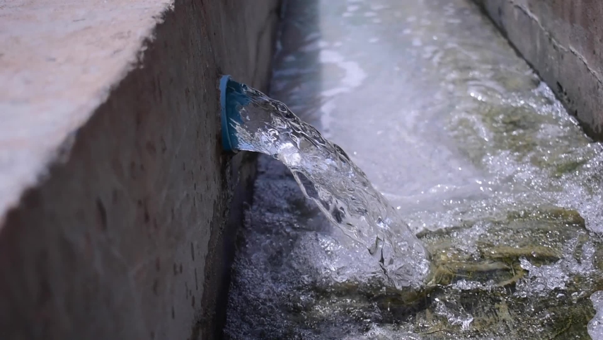 Water flows from the pvc pipe into the canal.