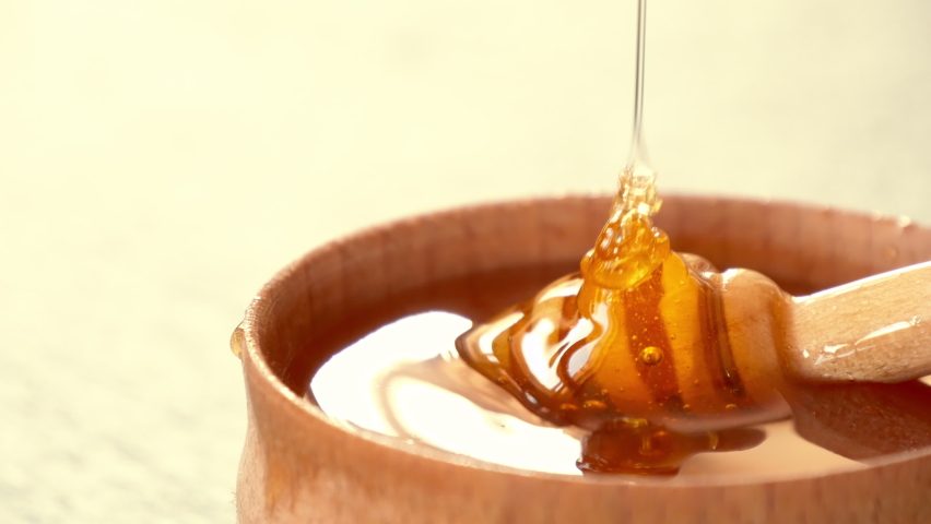 Liquid Organic Honey on a Special Honey Spoon in Wooden Bowl Close Up Shot. Healthy Food Concept. Honey Dripping to a Honey Dipper | Shutterstock HD Video #1058664010