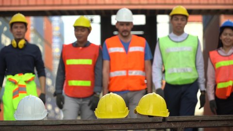 group of diverse worker Take off safety helmet and walking out to finish work or get off work at factory or Container Cargo site outdoor