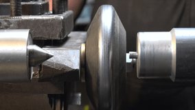Close-up video of a man working with metal on a lathe
