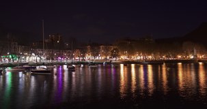 beautiful time lapse of the city of lecco italy at night, view of the lake with boats and city lighting