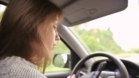 The woman answers the phone while driving. Driver creates danger by talking on the phone while driving