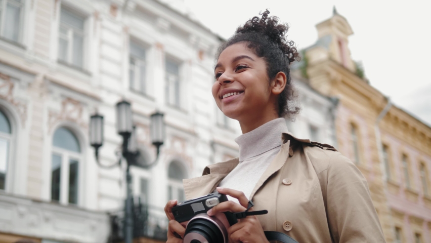 African American woman with analog camera making photo in park, safe travel and explore, walking hiking tours, black tourist girl in wild forest, generation z lifestyle, teenager photographer portrait | Shutterstock HD Video #1058681509