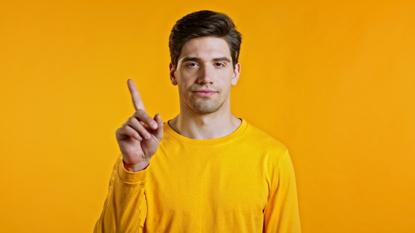 Man disapproving with no finger sign make negation gesture. Denying, Rejecting, Disagree, Portrait of guy on yellow background. | Shutterstock HD Video #1058683591