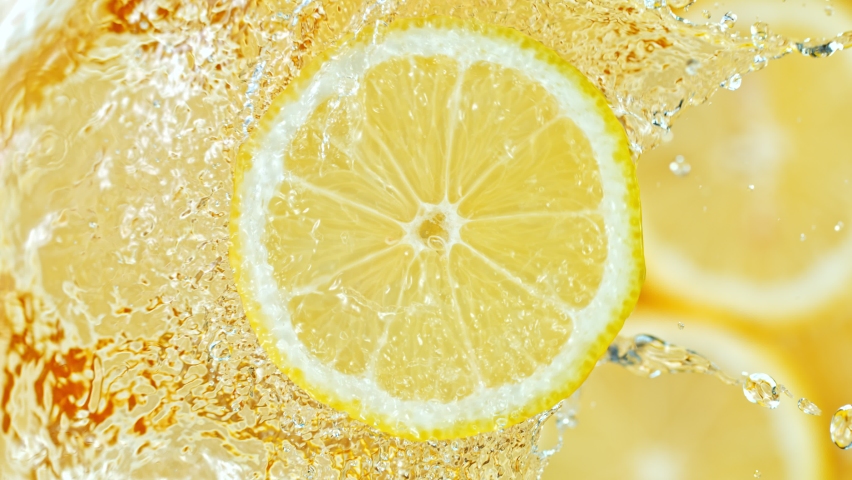 Super Slow Motion Shot of Splashing Water on Rotating Lemon Slice at 1000fps. Royalty-Free Stock Footage #1058684224