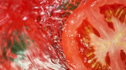 Super Slow Motion Shot of Splashing Water on Rotating Tomato Slice at 1000fps.