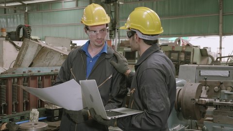 Two engineer man and partner work with laptop computer and having agreement for success together in factory industrial, planning and project for blueprint, employee talking and shake hand.