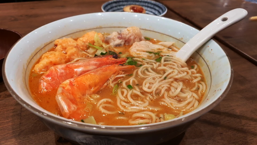 Shrimp Ramen noodle soup with Chinese Wonton dumplings in a restaurant in Singapore. A fusion of Japanese and Chinese cuisine.