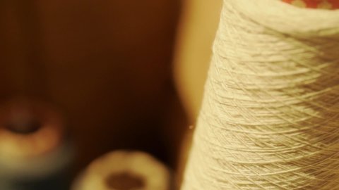 close-up shot of thread unrolled from reel. slow motion.