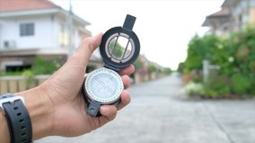 man holding compass on blurred background. for activity lifestyle outdoors freedom or travel tourism and inspiration backpacker alone tourist travel or navigator video 4K