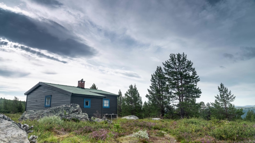 Time lapse of old Norwegian cabin on the mountain and dramatic clouds