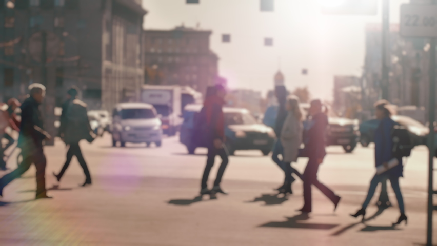 Lens blur, out of focus. A crowd of pedestrians is walking along the street against the background of passing cars. People walk around the big city. City life. Slow motion Royalty-Free Stock Footage #1058708497