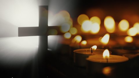 Cross and many candles in a dark background.