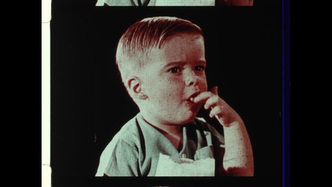 1950s USA. Drive-in Movie Theater Intermission Announcement. Young Boy Eats Popcorn, Young Girl eats Candy Bar, Woman Sips Coffee. 4K Overscan Showing Edge Lines and Sprocket Holes
