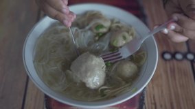 Eating Meatballs with Noodle Soup on table