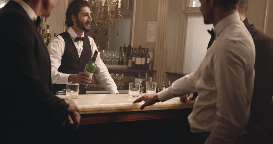 Male bartender serving drinks to group of men at party. Barman serving alcohol to guest at a nightclub. 
 Royalty-Free Stock Footage #1058735068