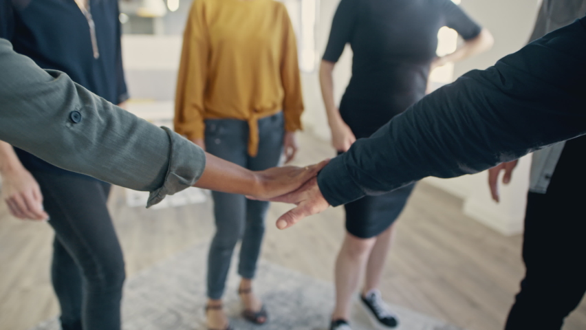 Multi-ethnic businesspeople putting their hands on top of each other and clapping. Business team making a stack of hands showing unity.
 Royalty-Free Stock Footage #1058735134
