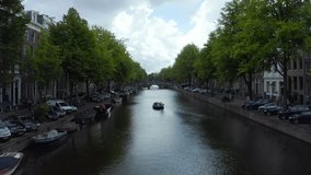 Amsterdam Canal with Boat and Dutch Flag waving in wind, forward Aerial  - Powered by Shutterstock - Get 15% off with code: PIKWIZARD15