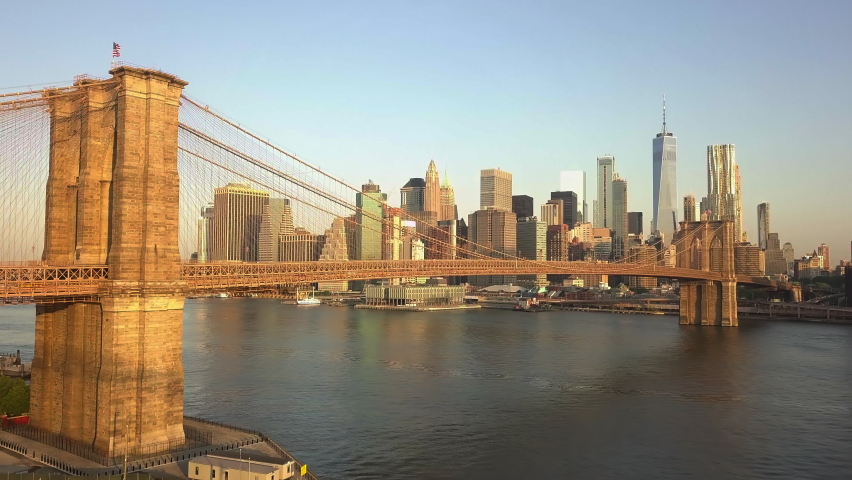 AERIAL: Flight towards Brooklyn Bridge with Manhattan and East River view at Sunrise, Sunset  Royalty-Free Stock Footage #1058741620
