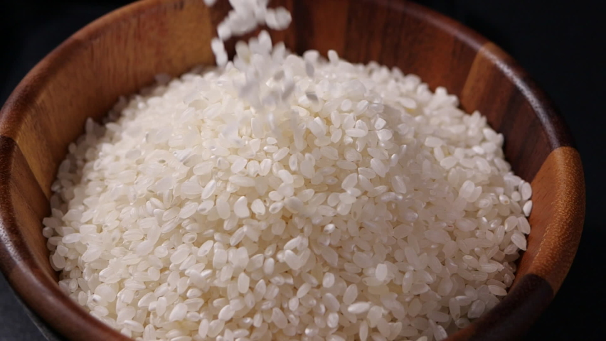 Japanese rice falling in slow motion. Raw rice grain in wooden bowl Royalty-Free Stock Footage #1058743993