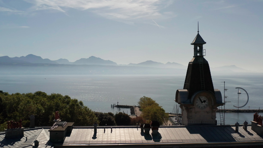 Aerial dolly of clock tower overlooking Lake Geneva in Switzerland